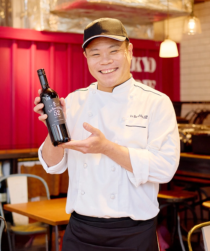 レストランの店内でワインを手にするFさん