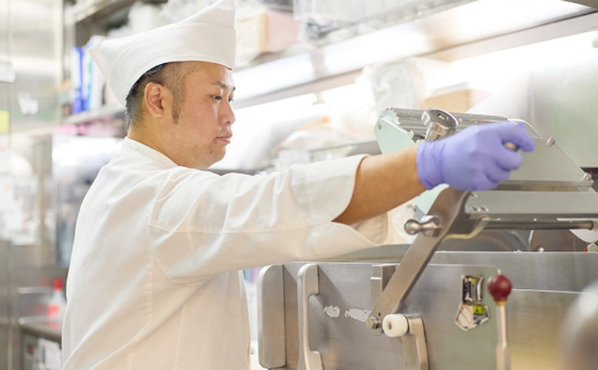 精肉の機械を操作するAさん