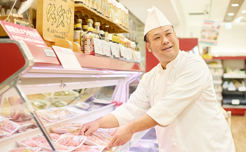 精肉売場で商品を並べるAさん