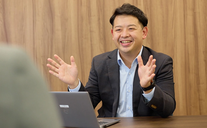 会議室で話すTさん