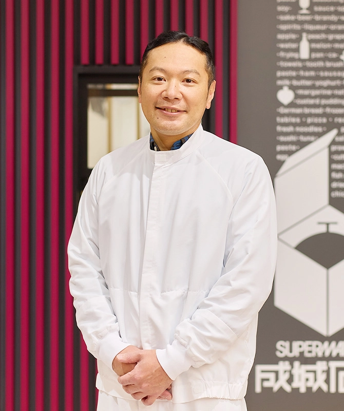 セントラルキッチンの入り口に立つKさん